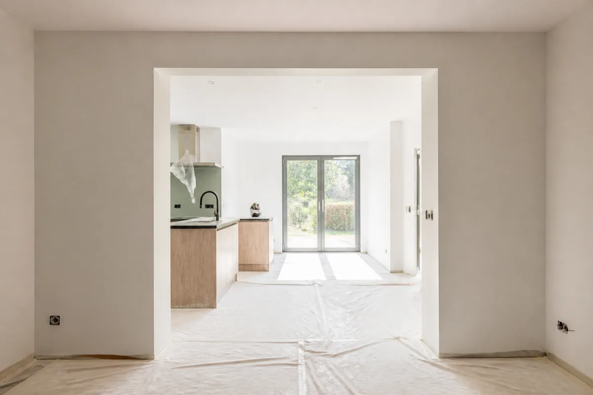 Ouverture terminée entre deux pièces, linteau habillé et sol protégé par des bâches