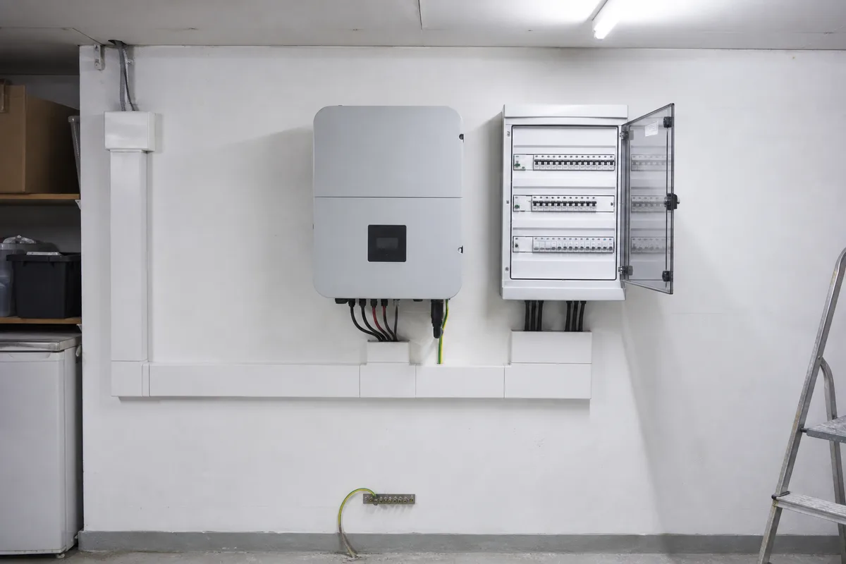 Onduleur et coffret électrique installés dans un local technique de maison individuelle